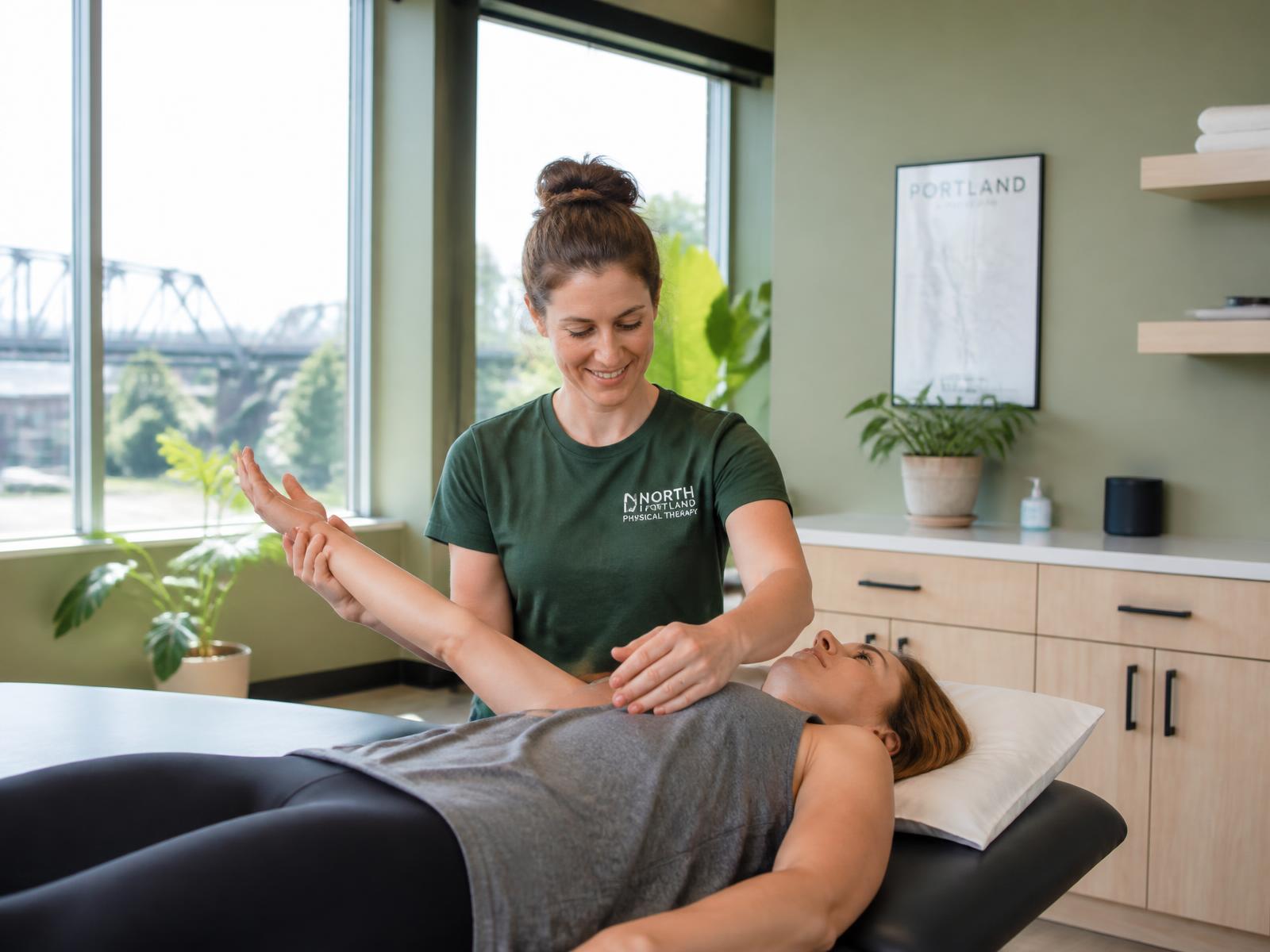 A physical therapist guiding a patient through a shoulder mobility assessment at Peak Performance Wellness in Portland